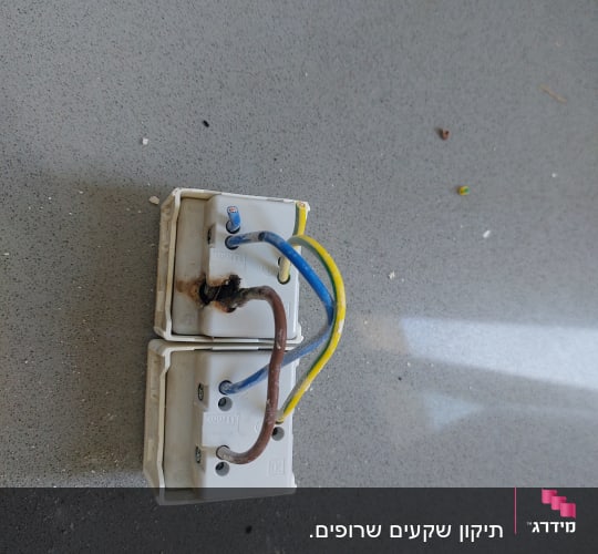 שני שקעים עם חוטים חשמליים חשופים על שולחן